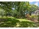 Beautifully landscaped backyard with mature trees offering shade and a small storage shed at 1468 Woodhurst Dr, Rock Hill, SC 29732