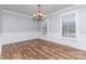 A dining room with elegant trim, wood-look floors, chandelier, and plantation shutters at 1468 Woodhurst Dr, Rock Hill, SC 29732