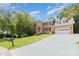 Attractive brick home with a well-maintained lawn, mature trees, and a long driveway leading to a two-car garage at 1468 Woodhurst Dr, Rock Hill, SC 29732