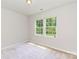 Bright bedroom featuring plush carpeting and a pair of windows offering serene views at 1552 Trentwood Dr, Fort Mill, SC 29715