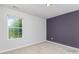 Neutral bedroom offers carpeted floors, large window, and an attractive, deep purple accent wall at 1552 Trentwood Dr, Fort Mill, SC 29715