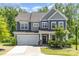 Charming two-story home featuring a two-car garage, stone accents, and a well-maintained front yard with mature trees at 1552 Trentwood Dr, Fort Mill, SC 29715