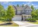 Beautiful home with a two-car garage, manicured lawn, and a welcoming front porch framed by stone pillars at 1552 Trentwood Dr, Fort Mill, SC 29715