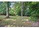 A large, lush backyard with mature trees offers shade and privacy at 15546 Thompson Rd, Mint Hill, NC 28227