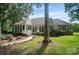 Exterior view of the home's rear showcasing the landscape and patio at 15546 Thompson Rd, Mint Hill, NC 28227
