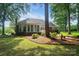 Beautiful landscaped backyard with brick home exterior and fountain feature at 15546 Thompson Rd, Mint Hill, NC 28227