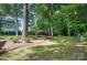 Backyard with large trees and a pergola-covered patio for relaxing and entertaining at 15546 Thompson Rd, Mint Hill, NC 28227