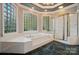 Bright bathroom featuring a soaking tub with glass block windows and a separate glass shower at 15546 Thompson Rd, Mint Hill, NC 28227