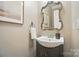 Elegant powder room featuring a decorative mirror, modern sink, and stylish fixtures at 15546 Thompson Rd, Mint Hill, NC 28227