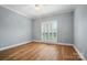 Bedroom with wood floors, white trim, and window with shutter style blinds at 15546 Thompson Rd, Mint Hill, NC 28227