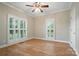 Bedroom with hardwood floors, a ceiling fan, and windows with white shutters at 15546 Thompson Rd, Mint Hill, NC 28227