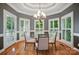 Bright dining area with hardwood floors, modern chandelier, and natural light streaming through shuttered windows at 15546 Thompson Rd, Mint Hill, NC 28227