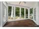 Sunroom with large windows showcasing the natural backyard landscape, carpeted floors, and a ceiling fan at 15546 Thompson Rd, Mint Hill, NC 28227