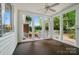 Relaxing sunroom with large windows offering backyard views, carpeted floors, and a ceiling fan at 15546 Thompson Rd, Mint Hill, NC 28227
