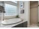Elegant bathroom features a soaking tub, glass block window, and tiled shower at 1959 Landry Ln, Rock Hill, SC 29732