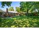 Lush backyard with mature trees, a brick house, a deck, and well-maintained landscaping at 2100 Stonewood Dr, Charlotte, NC 28210