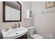 Cozy bathroom featuring a wood-framed mirror, white sink, toilet and coordinating fixtures at 2100 Stonewood Dr, Charlotte, NC 28210