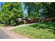 Well-manicured front yard with mature trees, green grass, and a charming home at 2100 Stonewood Dr, Charlotte, NC 28210