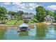 Aerial view of a luxurious waterfront home with manicured lawn, covered dock, and lush surrounding landscape at 299 Barber Loop, Mooresville, NC 28117