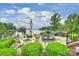Beautiful backyard with a fountain, Adirondack chairs, lush landscaping, and picturesque lake views at 299 Barber Loop, Mooresville, NC 28117