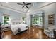 This primary bedroom has hardwood floors, many windows, and an elegant ceiling fan at 299 Barber Loop, Mooresville, NC 28117