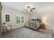 This bedroom has a decorative bed frame, ceiling fan, and large shuttered windows at 299 Barber Loop, Mooresville, NC 28117