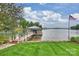 Waterfront view of a dock with boat house on a lush, landscaped lawn with an American flag waving in the breeze at 299 Barber Loop, Mooresville, NC 28117