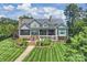 Elegant exterior of a two-story home with manicured lawn, fountain, and brick pathway leading to a covered porch at 299 Barber Loop, Mooresville, NC 28117