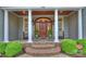 Inviting front porch with stately columns, a wood door, and elegant outdoor seating, creating a welcoming entrance at 299 Barber Loop, Mooresville, NC 28117
