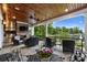 Outdoor living space with stone fireplace, built in grill, dining, seating and lake view at 299 Barber Loop, Mooresville, NC 28117