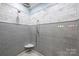 This luxurious shower features marble walls, dual shower heads, and gray accent tiling at 299 Barber Loop, Mooresville, NC 28117