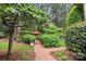 Lush backyard with brick path and mature trees at 3420 Maryhurst Ln, Charlotte, NC 28226