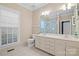 Bright bathroom with a large mirror, double sinks, and a shower with glass doors at 3420 Maryhurst Ln, Charlotte, NC 28226