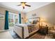 Comfortable bedroom features a large window, patterned bedding, and a ceiling fan at 3420 Maryhurst Ln, Charlotte, NC 28226