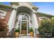 Elegant front door with a charming wreath, flanked by potted plants, set within a brick facade at 3420 Maryhurst Ln, Charlotte, NC 28226