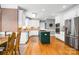 A bright kitchen features white cabinets, stainless appliances, a green center island, and hardwood floors at 3420 Maryhurst Ln, Charlotte, NC 28226