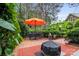Outdoor patio offers a cozy brick fire pit, orange umbrella, and an outdoor dining area perfect for relaxing at 3420 Maryhurst Ln, Charlotte, NC 28226