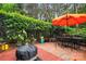 Brick patio features a cozy outdoor dining area, a brick fire pit, and is surrounded by greenery at 3420 Maryhurst Ln, Charlotte, NC 28226