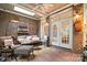 Sunny brick-walled sunroom with brick floor and ceiling fan at 3420 Maryhurst Ln, Charlotte, NC 28226