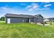 Expansive backyard showcases a well-maintained lawn, patio area, and dark blue siding, perfect for relaxation and entertaining at 3615 Kimber Ln, Sherrills Ford, NC 28673