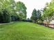 A spacious, well-maintained backyard offers plenty of room for activities, framed by lush greenery and a black fence at 6005 Abergele Ln, Matthews, NC 28104