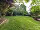 The sprawling backyard is an outdoor sanctuary with mature trees and manicured landscaping, offering peace and privacy at 6005 Abergele Ln, Matthews, NC 28104
