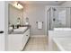 Bathroom featuring a double sink vanity, bathtub, and glass-enclosed shower at 6005 Abergele Ln, Matthews, NC 28104