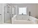 Bathroom with large soaking tub, separate glass shower, and bright window at 6005 Abergele Ln, Matthews, NC 28104