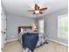 Cozy bedroom with ceiling fan and natural light from two large windows at 6005 Abergele Ln, Matthews, NC 28104