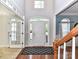 Bright foyer featuring hardwood floors, a staircase, and a decorative rug at 6005 Abergele Ln, Matthews, NC 28104