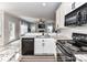 Modern kitchen with granite countertops and black appliances overlooking the living room at 6005 Abergele Ln, Matthews, NC 28104
