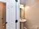 Classic powder room features pedestal sink and stylish lighting at 6005 Abergele Ln, Matthews, NC 28104