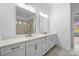 Bathroom featuring a double vanity with marble countertop and large mirrors and tiled shower in background at 6712 Cove Ln, Sherrills Ford, NC 28673