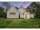 Two-story white farmhouse-style home with modern black trim, a covered porch and manicured lawn at 6712 Cove Ln, Sherrills Ford, NC 28673